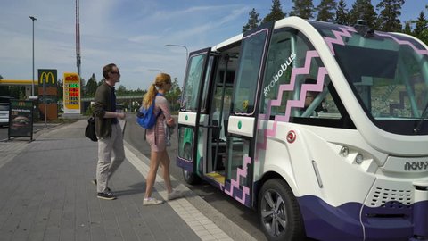 HELSINKI, FINLAND - JUNE 11, 2018: Passengers enter the automated remotely operated bus in Helsinki. Unmanned public transport on street.