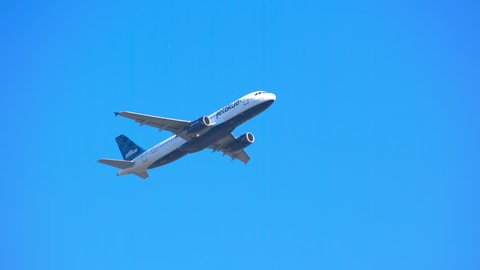 NEW YORK - 2018: JetBlue Airways Airbus A320-200 Commercial Jet Airplane Flying Overhead in a Clear Blue Sky after Taking Off from JFK International Airport