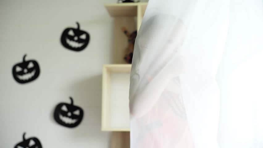 Portrait Asian little girl plays and turns around inside the white clean curtain with fun and happiness.