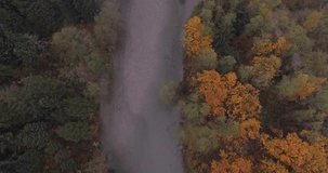 4k drone footage flying through the mountains over a clear river with fog, low clouds and fall weather.