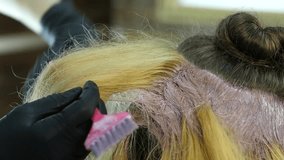 hairdresser makes hairstyle, dye for a teenager in a beauty salon. Hair covered in dye. slow motion