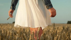 In this beautiful slow motion video shot you can see young, beautiful and attractive girl rotating around herself in wheat grain field. Her white dress beautifully floats in the air.