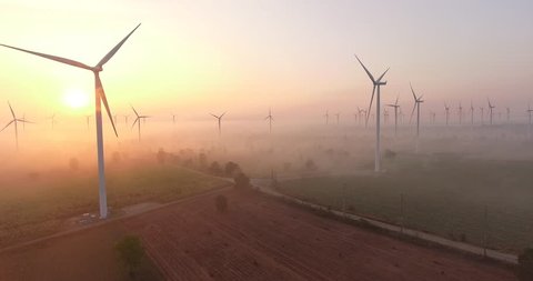Aerial view of Wind turbines Energy Production- 4k aerial shot on sunrise. 4k drone footage turbines at sunrise with clouds. Sustainable development, environment friendly, renewable energy concept.