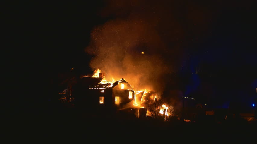 Burning house and fire fighters, parts of the roof collapses during clip
