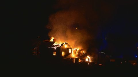Burning house and fire fighters, parts of the roof collapses during clip