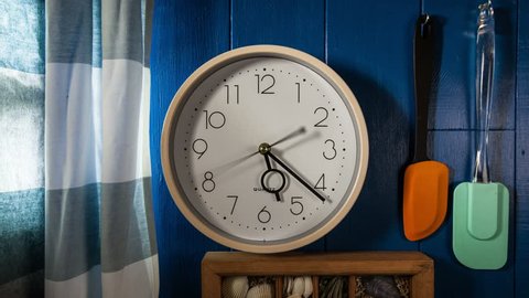 Time lapse clock - camera rotates with the big hand of a round kitchen clock from 06:00 to 07:00, before and after that the camera stops.