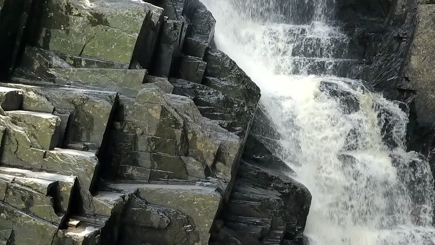 Close up of wet gray rocks next Little Wilson waterfall in Maine.