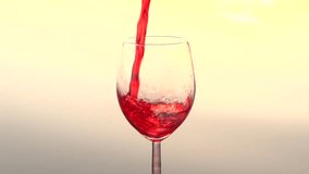 Red wine is poured into a wine glass. A beautiful splash of wine in a wine glass. Slow motion 240 fps. High speed camera shot. Full HD 1080p. 