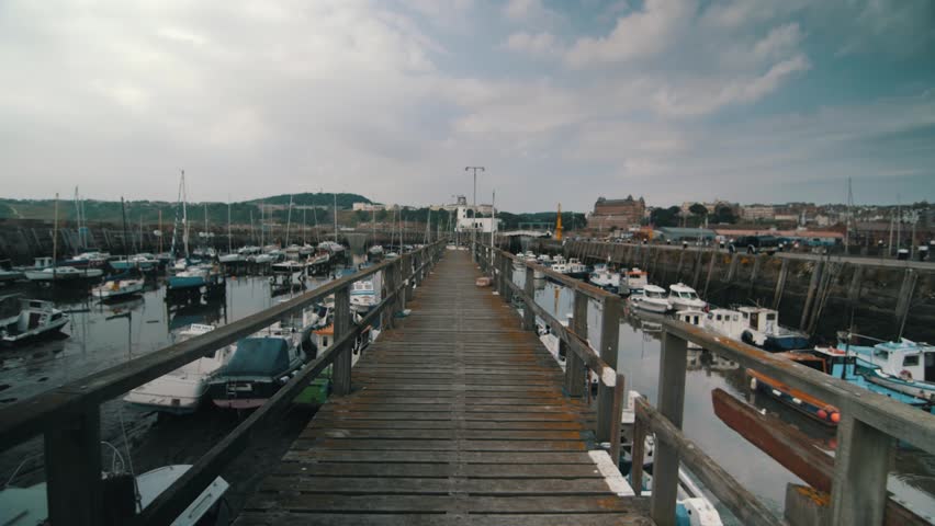 A gimbal shot of a wooden walkway in Scarborough harbour.