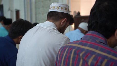 Footage of Muslim men praying in a mosque.