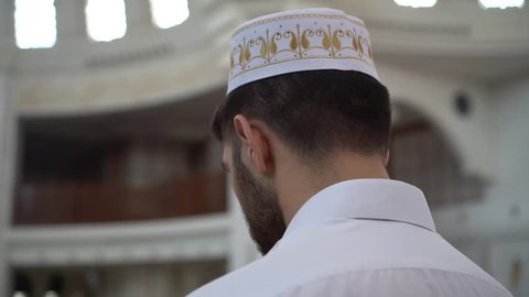 Footage of a Muslim man praying in a mosque.