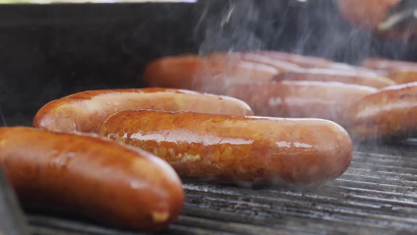 bratwurst grilling barbequing close up in the nature stock video Royalty-Free Stock Footage #1016513317