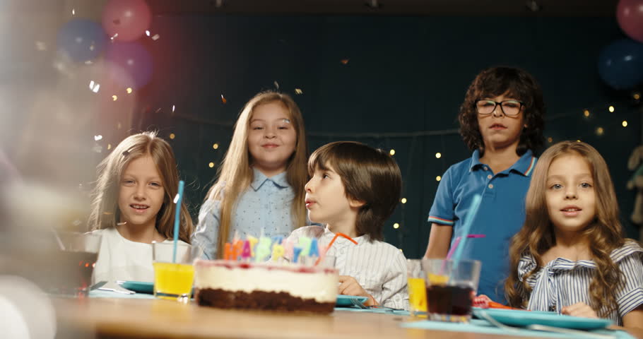 Children having birthday party. Group of kids celebraing birthday of their friend, cheering, having fun - happy childhood concept 4k