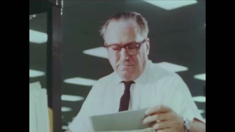 CIRCA 1960s - Tax workers are shown in the error resolution department and microfilm and computers are used.
