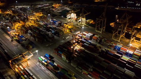 Aerial hyperlapse - Night shot of busy industrial port. Footage of seamless transport routes supply chain