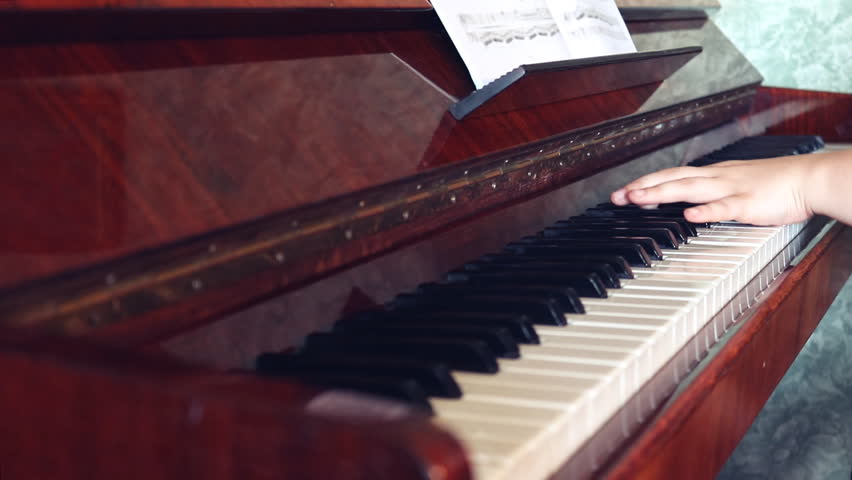 Hands playing paino with music stand