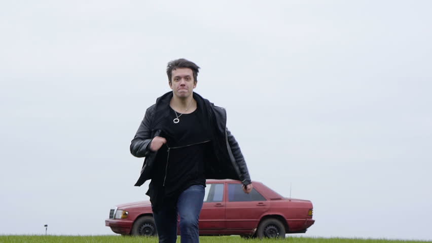 The guy walks away from the burning red car, car crash survivor
