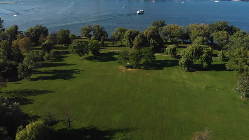 Aerial view of Toronto skyline, Centre Island and Lake Ontario on a summer day in Toronto, Ontario, Canada, tilt up. Royalty-Free Stock Footage #1016535844