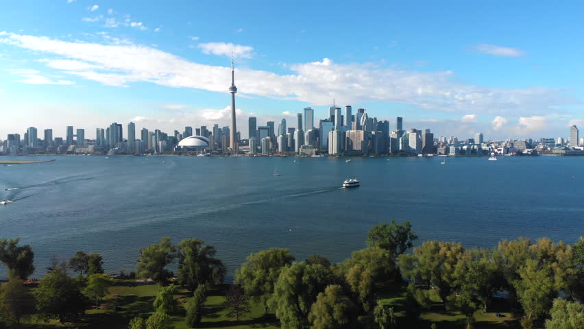 Aerial view of Toronto skyline, Centre Island and Lake Ontario on a summer day in Toronto, Ontario, Canada, tilt up. Royalty-Free Stock Footage #1016535844
