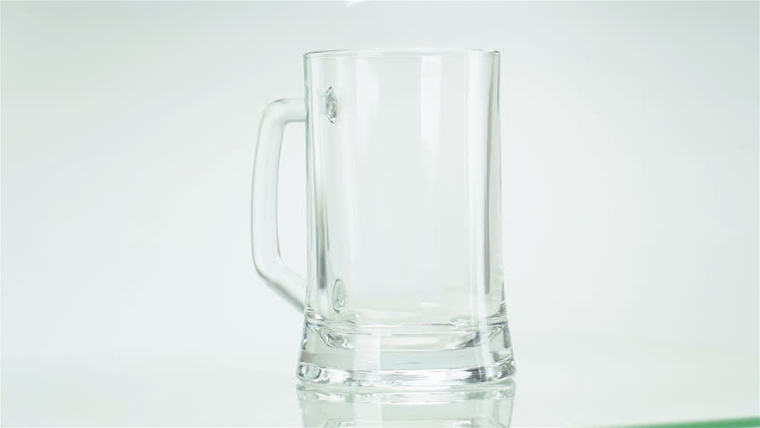 Beer is poured into a glass, on the wall foam flows on a white background, slow motion shooting | Shutterstock HD Video #1016538007