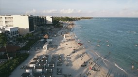 4K Epic Aerial shot of Playa Del Carmen Mexico beach cozumel flyover with families and people having fun on the beach swimming and boats marina with hotels and resorts buildings waterfront ocean