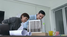 Architects and Businesswoman are working together on a building model. Business woman suggest idea to designer at modern office. concept of construction, architecture, development and creative.