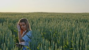 Woman agronomist looking at wheat ears and writing something in the notebook. RAW video record.
