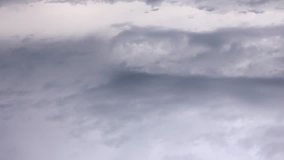 Video storm clouds rolling through landscape, mountains in background, water in foreground. Majestic as rain falls in the middle with sunlight streaming down behind it.