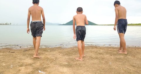Boys jumping into water in lake at sunset, joyful in countryside life concept 库存视频