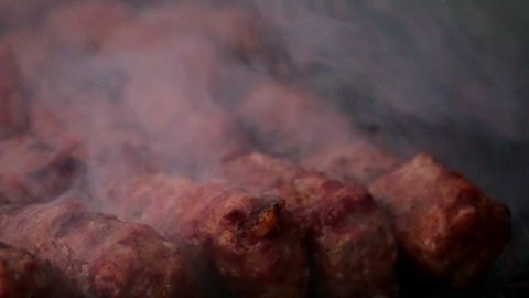 Romanian traditional food Meat Balls "mici" on grill. Slow motion