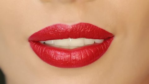Closeup of a beautiful woman lips with beautiful makeup sending air kiss . Close up of girl's mouth having flirty emotions and sending air kiss .