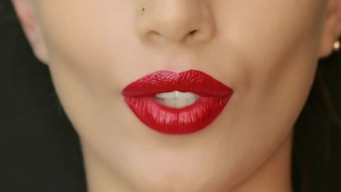 Closeup of a beautiful woman lips with beautiful makeup sending air kiss . Close up of girl's mouth having flirty emotions and sending air kiss .