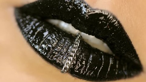 Closeup of a beautiful woman lips with beautiful black makeup sending air kiss . Close up of girl's mouth having flirty emotions and sending air kiss .