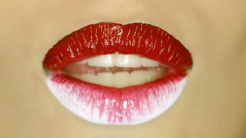 4k Closeup of a beautiful woman lips with beautiful red and white makeup sending air kiss . Close up of girl's mouth having flirty emotions and sending air kiss .