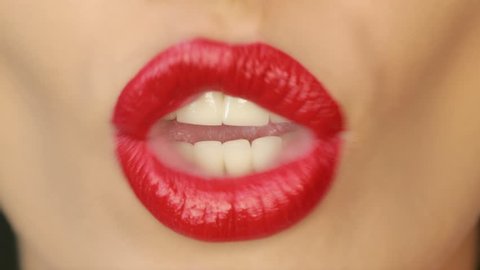 4K Closeup of a beautiful woman lips with beautiful red make up sending air kiss . Close up of girl's mouth having flirty emotions and sending air kiss .