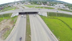 Aerial view of highway in city. Clip. Cars crossing interchange overpass. Highway interchange with traffic. Aerial bird's eye photo of highway. Expressway. Traffic on modern complex road intersection