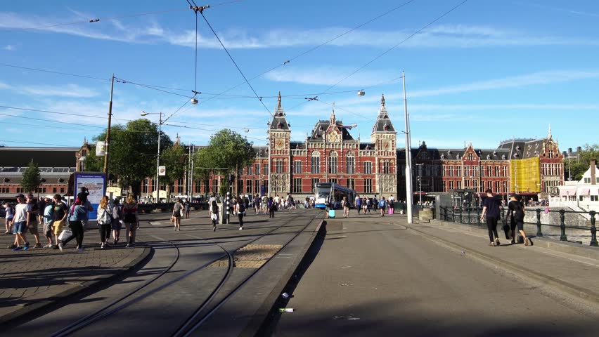 Tram departs from the Central Railway Station in Amsterdam, Europe.