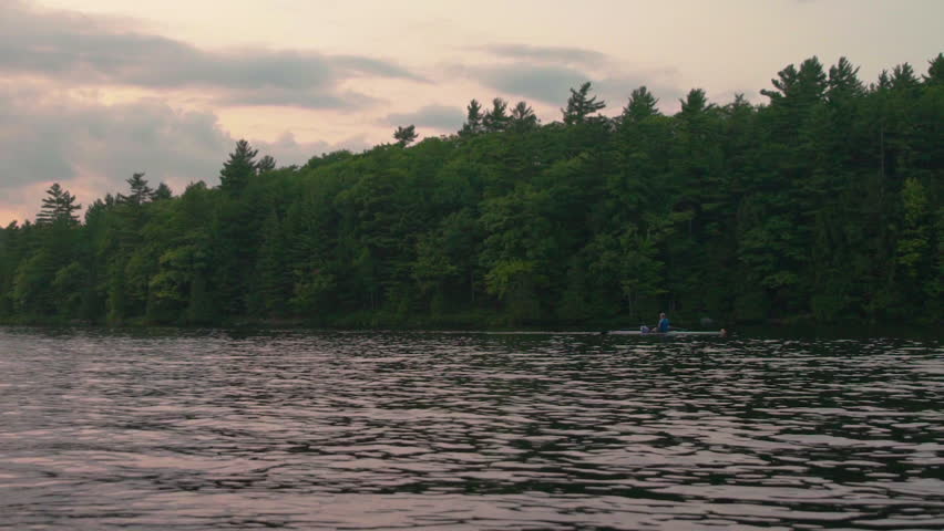 Rower on river at dusk in slow motion