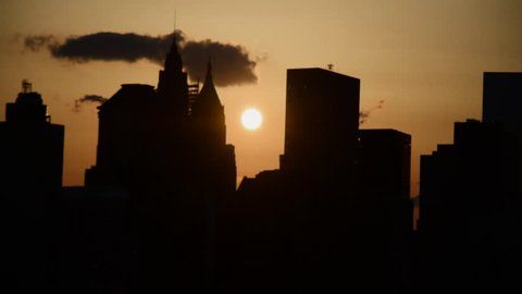Sun setting over tall city buildings.
