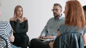 Young woman talking with therapist during meeting of support group