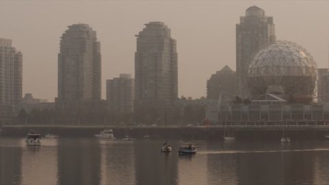 Vancouver's false creek covered in smoke from the forest fires, water taxi drives by with science world in the background
