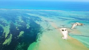 Aerial drone video of tropical caribbean bay with atoll and beautiful turquoise and sapphire clear sea forming a blue archipelago and blue lagoon
