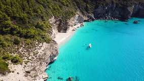 Aerial bird's eye view video taken by drone of tropical mediterranean seascape and sandy beach with turquoise clear waters and pine trees