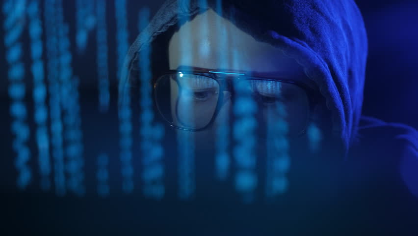 Close up of digital terrorist looking into the monitor screen in the darkness. Smooth blue shining. ProRes 422 Royalty-Free Stock Footage #1016625280