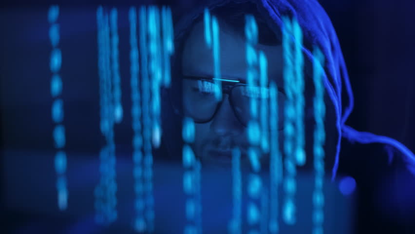 Genius cyber security manager with binary code reflection on his face in dark room at night. . Reflection effect, lens flare. ProRes 422 Royalty-Free Stock Footage #1016625289
