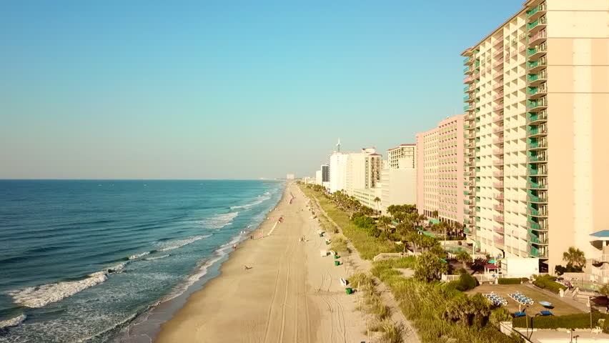 Aerial view moving over the Myrtle Beach with hotels, buildings and the ocean.