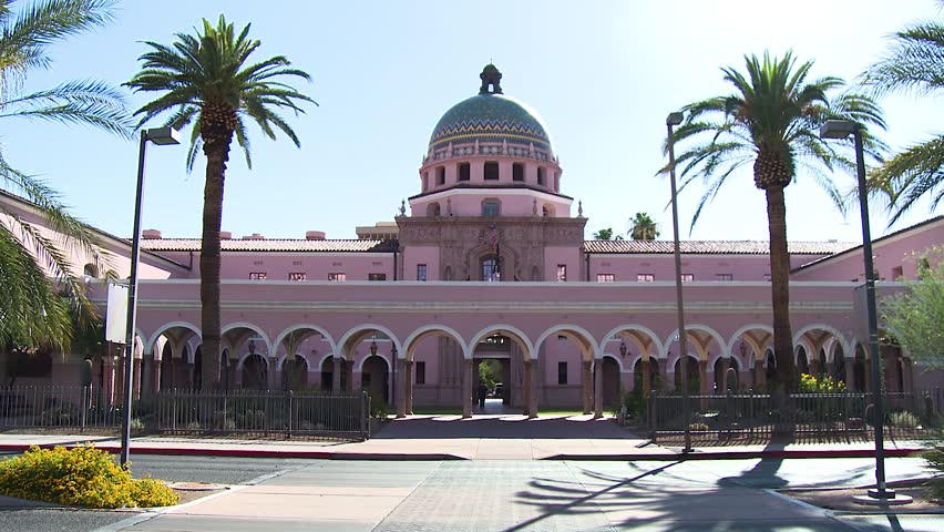 Wide, static shot of the beautiful Pima County Courthouse in Tuscon Arizona on a sunny day with palm trees in foreground.