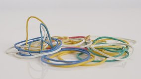 Various rubber bands on white background 4K tilting footage