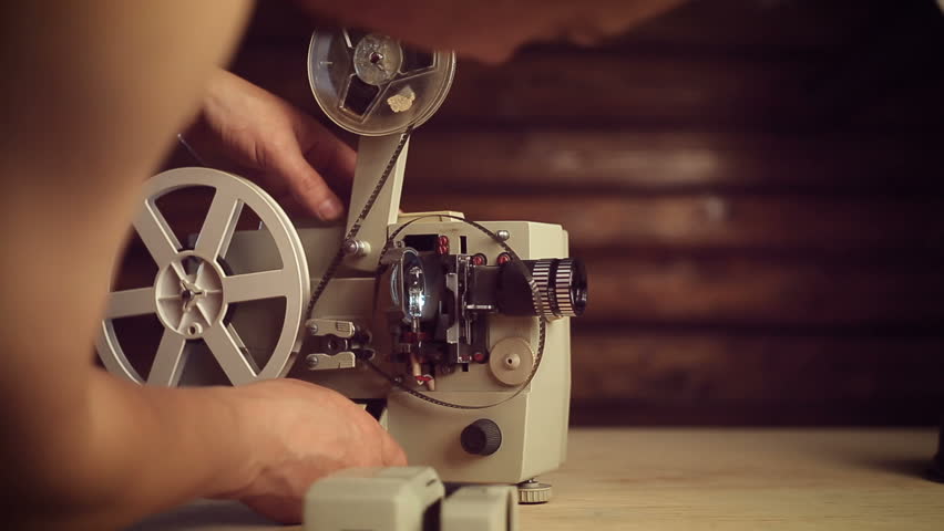 male hands include an old movie projector.