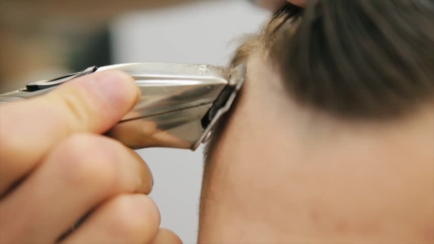 Male haircut with electric razor. Close up of hair trimmer hairstyle. Professional hairdresser cutting hair with hair clipper. Man hairdressing with electric shaver Royalty-Free Stock Footage #1016632924